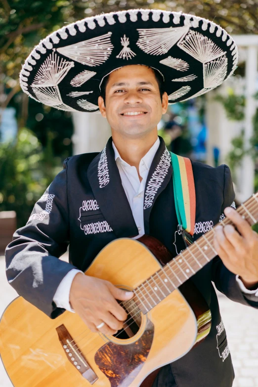 a man in a sombrena playing a guitar, an album cover, inspired by Germán Londoño, pexels contest winner, while smiling for a photograph, wearing authentic attire, bay area, official government photo