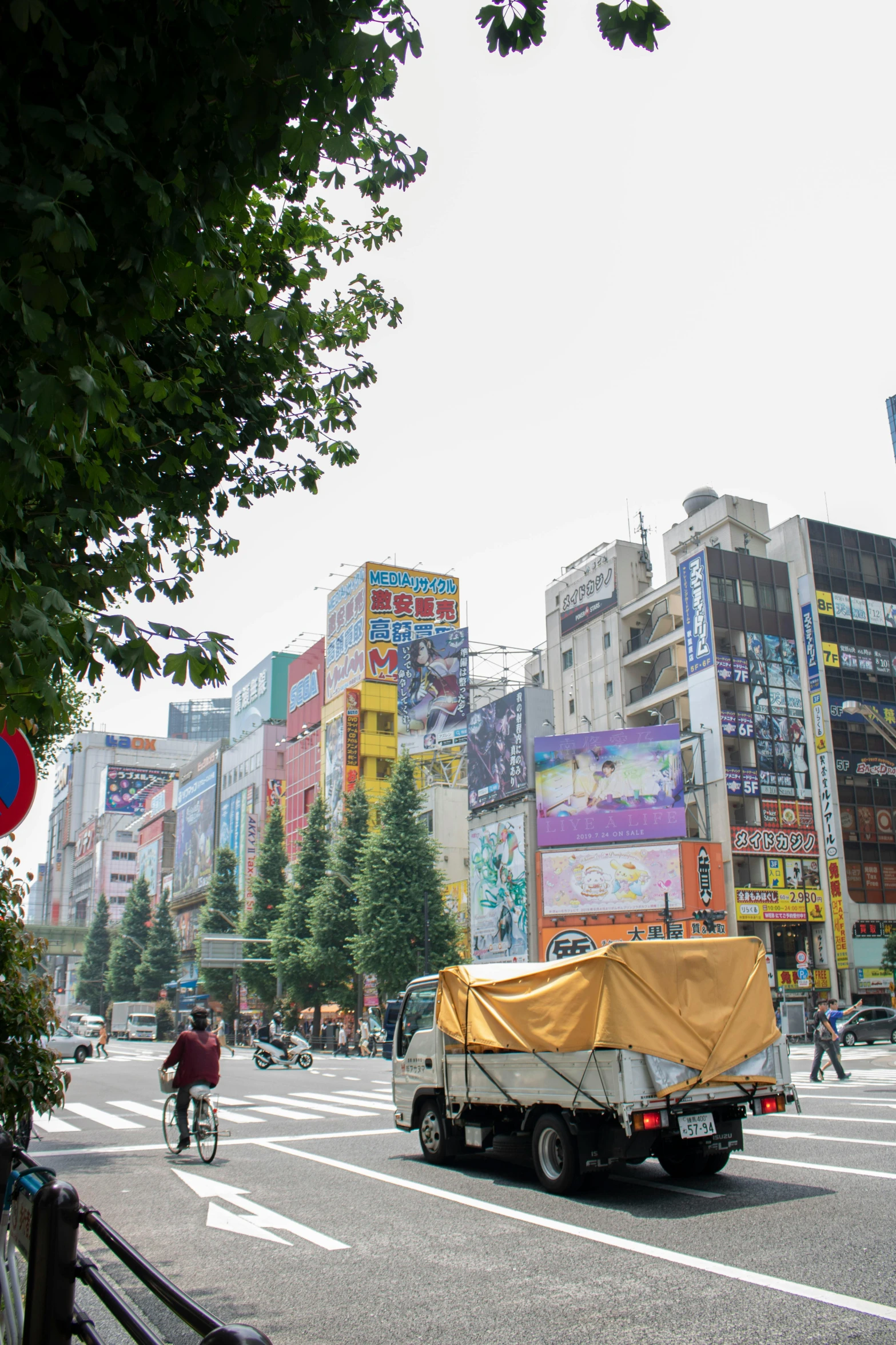 a truck driving down a city street next to tall buildings, toyism, japan lush forest, traffic signs, square, billboard image