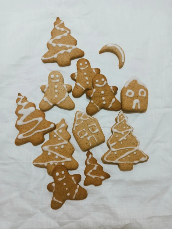 a pile of ginger cookies sitting on top of a table, by Géza Udvary, reddit, process art, with familiar sprites, christmas tree, ☁🌪🌙👩🏾, different shapes and sizes