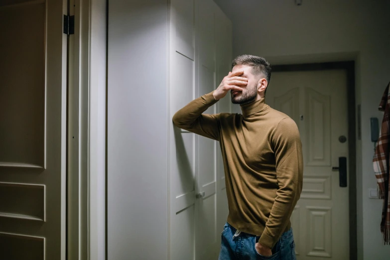 a man taking a picture of himself in the mirror, a picture, inspired by Elsa Bleda, pexels contest winner, crying fashion model, leaning on door, he is wearing a brown sweater, ptsd