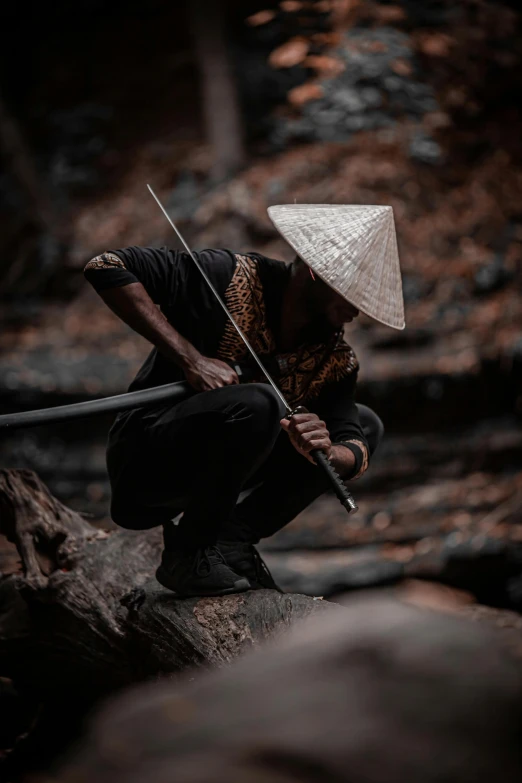 a person kneeling on a rock with a sword, inspired by Kanō Hōgai, pexels contest winner, pointy conical hat, vietnam war, ninja outfit, bamboo