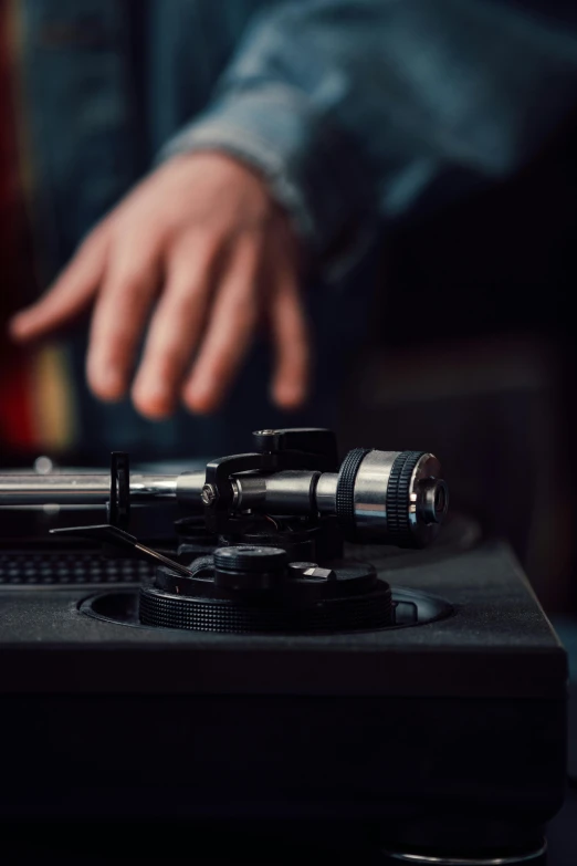 a close up of a person playing a record on a turntable, an album cover, trending on pexels, mechanics, holding microphone, machines cocktail music, [ cinematic