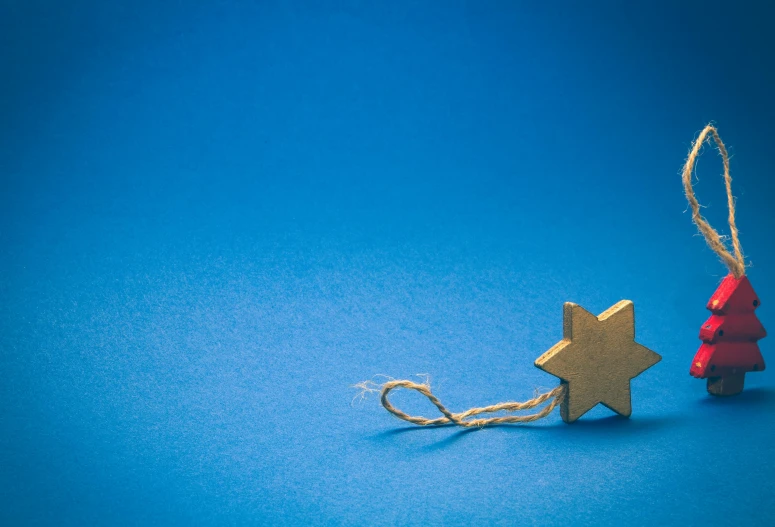 a wooden puzzle piece next to a christmas tree, pexels, minimalism, solid blue background, michellin star, jerusalem, gold