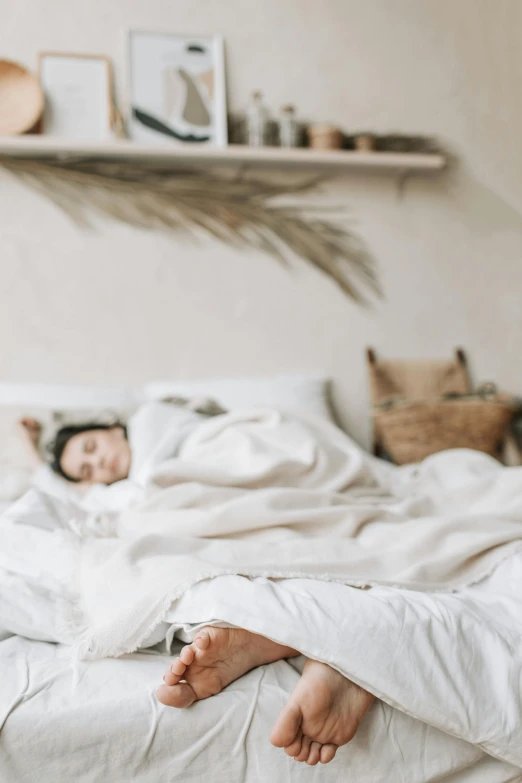 a person laying in a bed under a blanket, inspired by Elsa Bleda, pexels contest winner, in a white boho style studio, happily tired, slightly pixelated, blurry