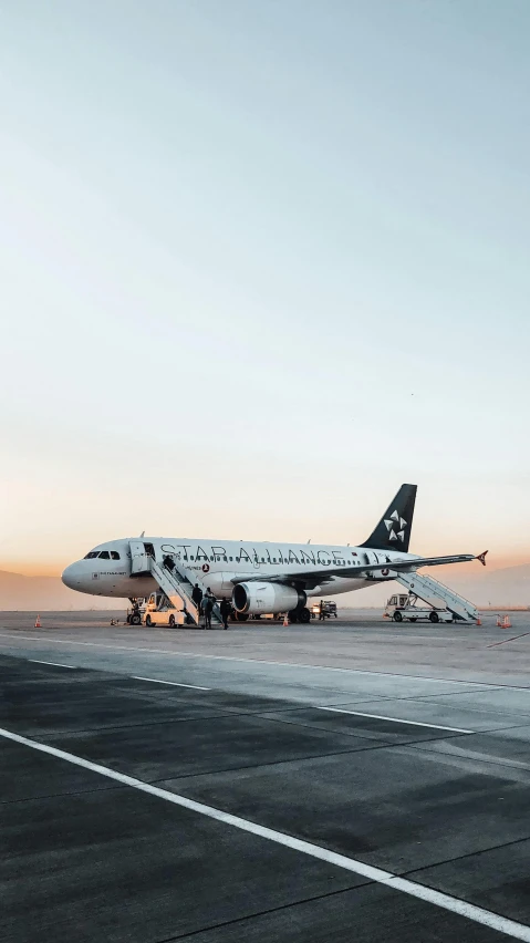 a large jetliner sitting on top of an airport tarmac, by Will Ellis, pexels contest winner, white with black spots, early dawn, instagram post, iceland photography