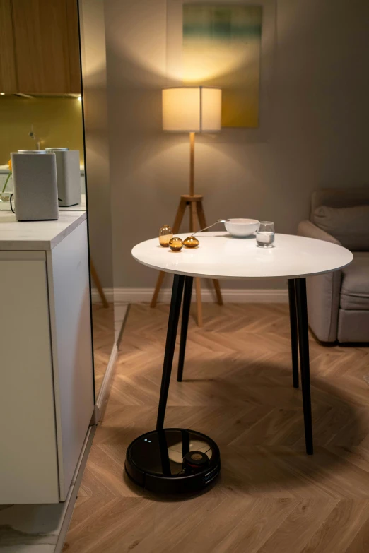 a white table sitting on top of a wooden floor, a picture, by Jan Tengnagel, happening, standing lamp luxury, breakfast, coffee, artificial warm lighting