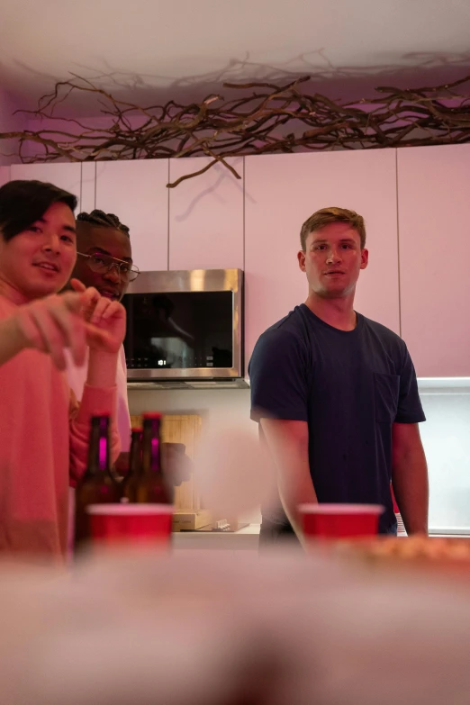 a couple of men standing next to each other in a kitchen, a picture, college party, bisexual lighting, cheers, asian male