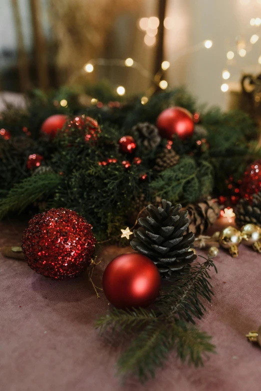 a close up of christmas decorations on a table, inspired by Ernest William Christmas, baroque, soft red lights, pinecone, full-size, beautifully soft lit