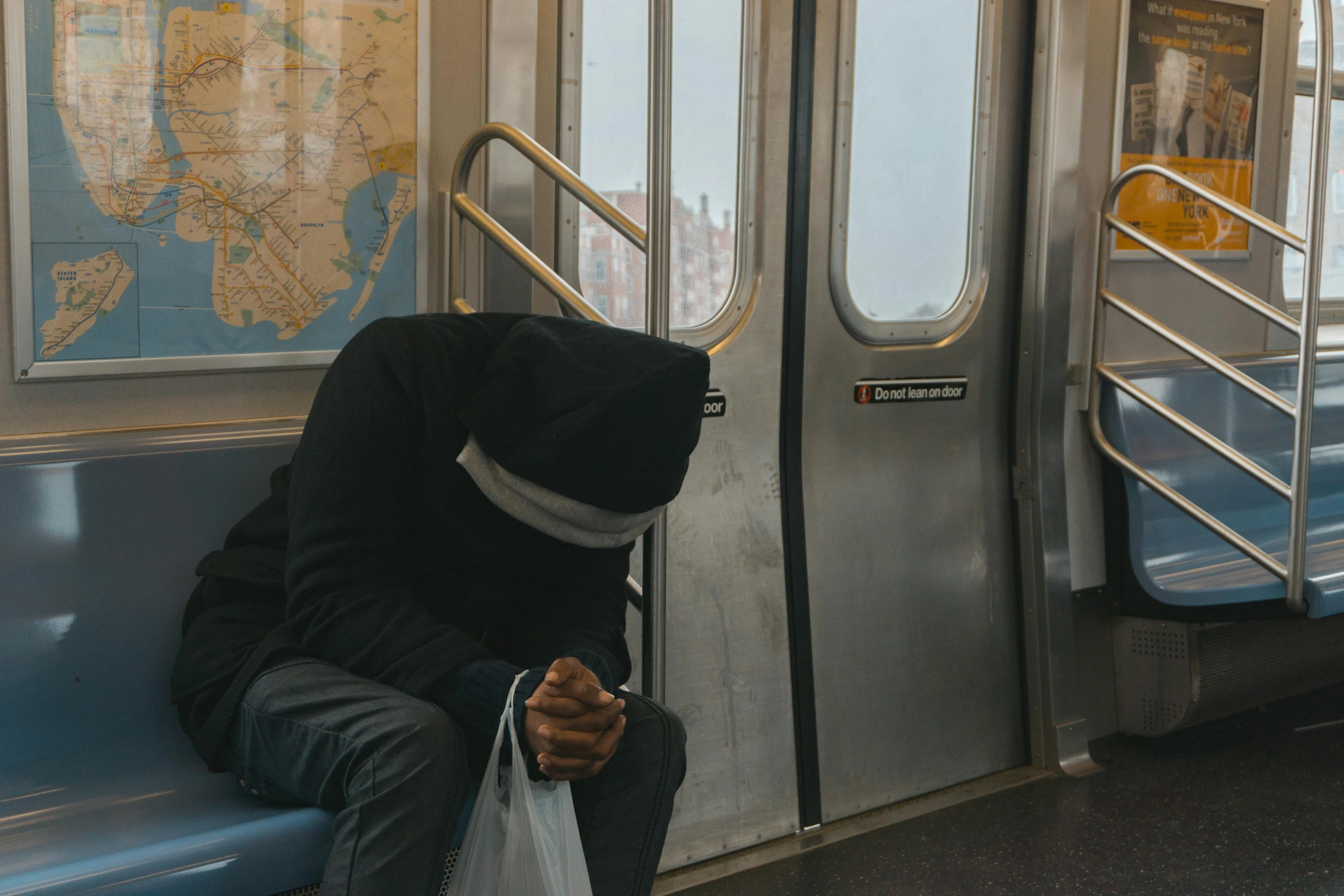 a man sitting on a train looking at his cell phone, an album cover, by Niko Henrichon, pexels contest winner, mf doom mask, in new york city, hiding, unconscious