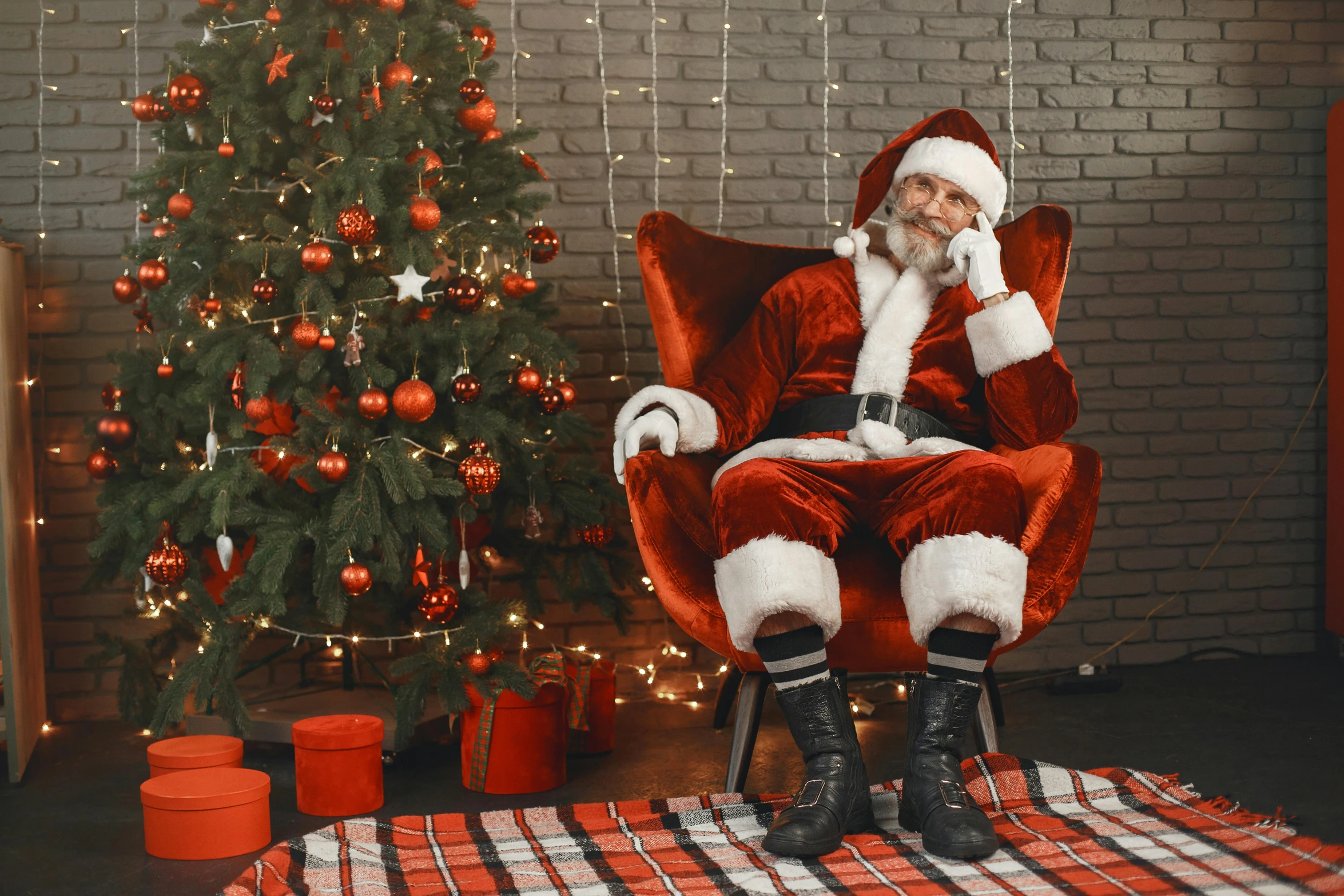 a santa claus sitting in a chair in front of a christmas tree, a photo, shutterstock, leather clothing and boots, 🎀 🍓 🧚, 64x64, ben watts