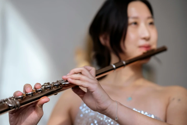 a woman holding a flute in front of her face, inspired by Wang Duo, unsplash, photorealism, ruan jia and fenghua zhong, person in foreground, transparent, avatar image