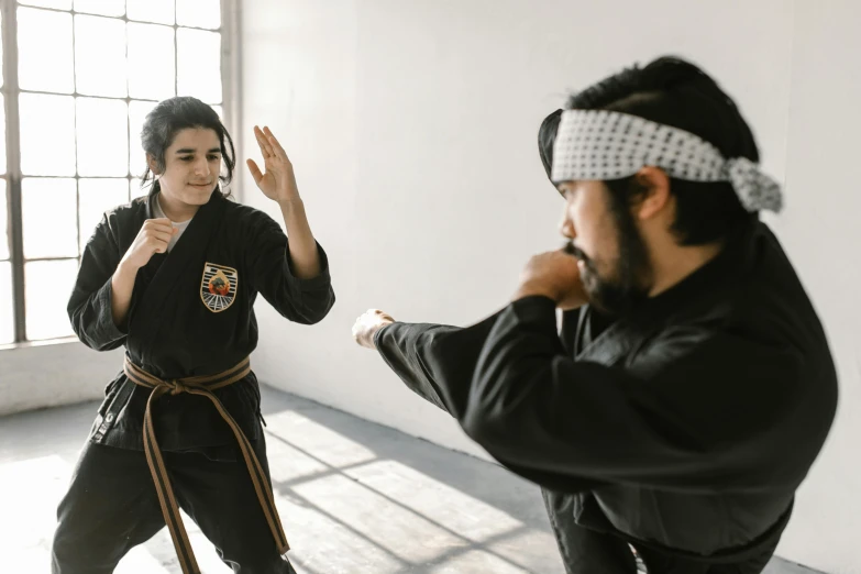 a man standing next to a woman in a room, inspired by Baiōken Eishun, pexels contest winner, getting ready to fight, profile image, ninjas, school class