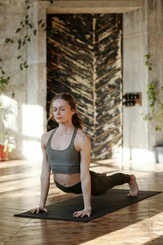 a woman doing a yoga pose on a yoga mat, by Carey Morris, pexels contest winner, renaissance, model with attractive body, indoor, panels, slate