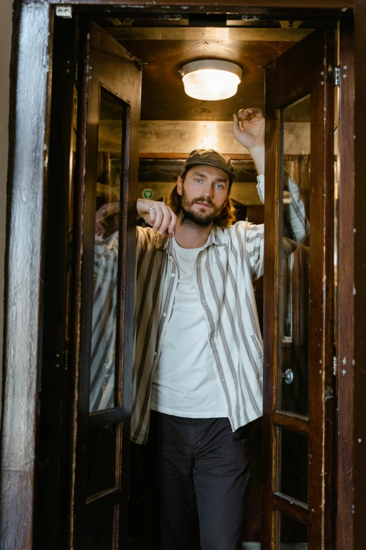 a man that is standing in a doorway, a portrait, unsplash, private press, hozier, charlie day, exiting from a wardrobe, standing in a restaurant