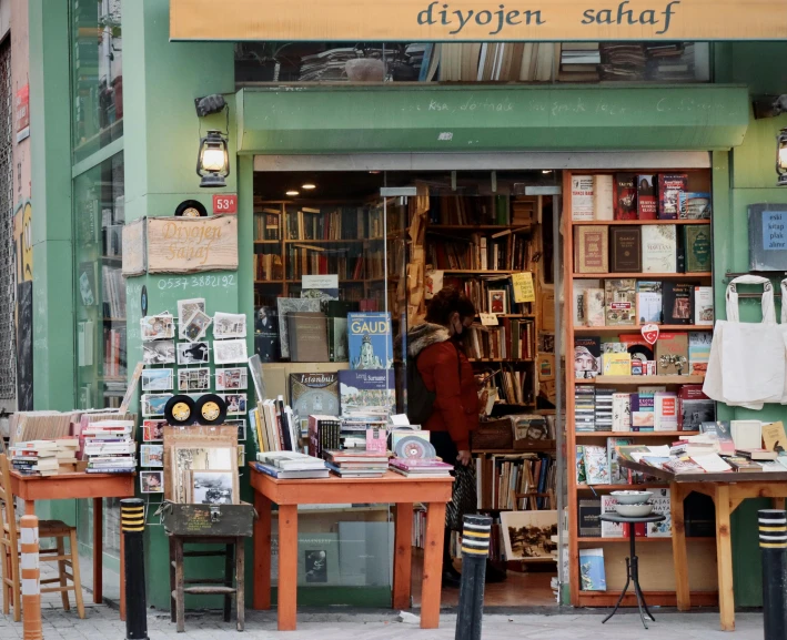 a book store with tables and chairs in front of it, pexels, private press, istanbul, a person standing in front of a, swedish, small in size