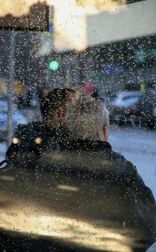 a man sitting on a bench in the rain, snowflakes falling, couple kissing, humans of new york, digital image