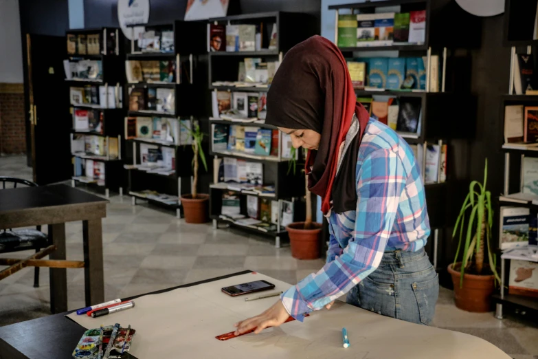 a woman that is standing in front of a table, by Zahari Zograf, pexels contest winner, hyperrealism, portrait of computer & circuits, reading in library, arab ameera al-taweel, from reading to playing games