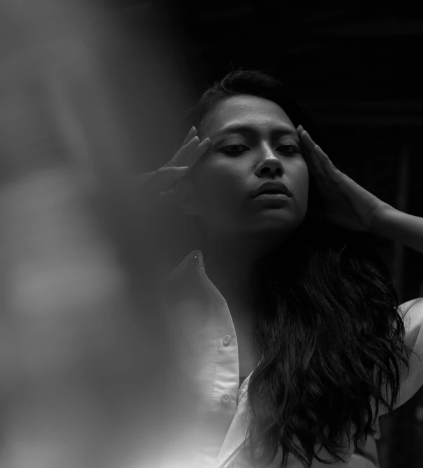 a black and white photo of a woman with long hair, by Adam Marczyński, unsplash, an asian woman, still from a music video, ignant, intense lighting