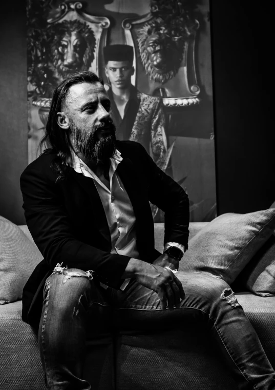 a black and white photo of a man sitting on a couch, a black and white photo, pexels contest winner, art photography, bearded and built, peter paul rebens, francoise nielly, marc silvestri