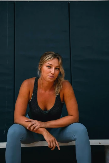 a woman sitting on a bench with a tennis racket, a portrait, unsplash, she is wearing a black tank top, alex jones, faded worn, casey cooke