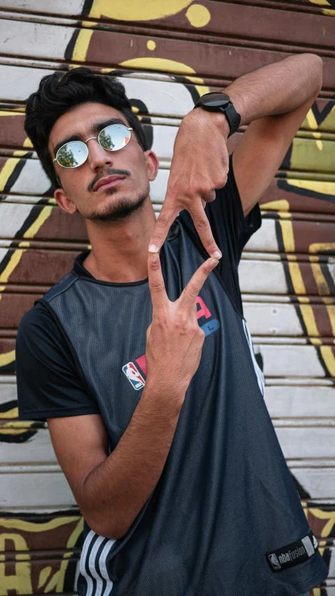 a man making a peace sign with his hands, by Ahmed Yacoubi, pexels contest winner, graffiti, black t - shirt, a handsome, pr shoot, profile image