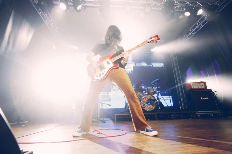 a man that is playing a guitar on a stage, pexels contest winner, charli bowater, syd, low shot angle, coloured