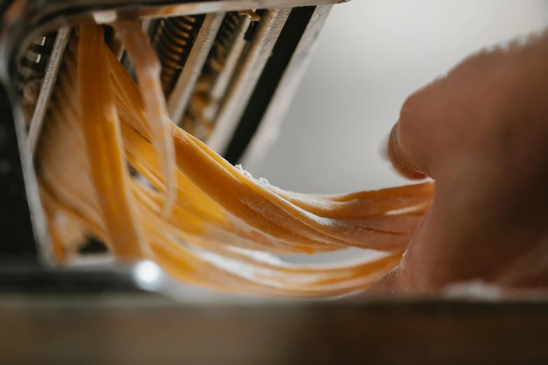 a close up of a person pulling pasta out of an oven, pexels contest winner, process art, caramel, thick looping wires, high quality product image”, ribbon