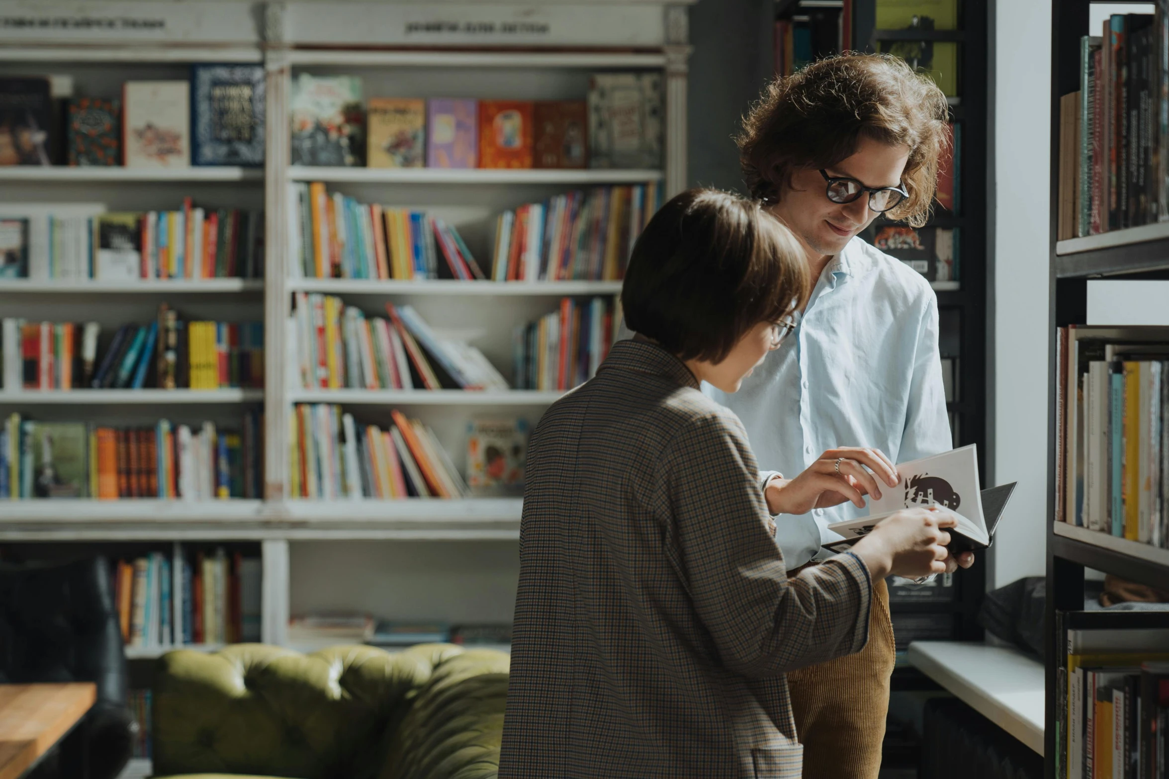 a couple of people standing in front of a book shelf, pexels contest winner, private press, small hipster coffee shop, avatar image, inherent vice, inspect in inventory image