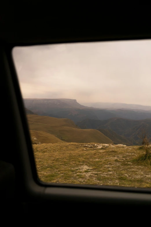 a view of the mountains through a car window, by Muggur, les nabis, overview, bulli, distant - mid - shot, canyons