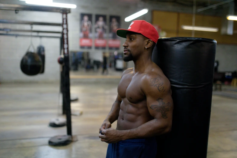 a man standing next to a punching bag, a portrait, by Sam Charles, pexels contest winner, les nabis, abdominal muscles, atiba jefferson, athletic crossfit build, profile image