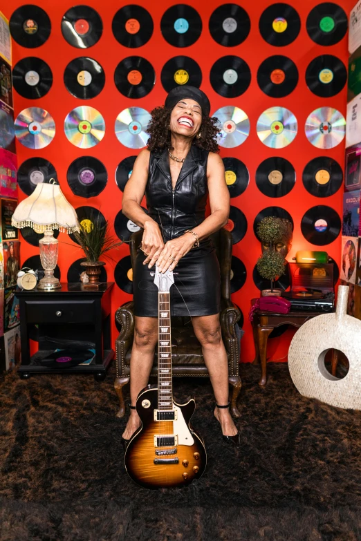 a woman standing in a room with a guitar, funk art, playful smirk, bootsy collins, jordan lamarre - wan, profile image