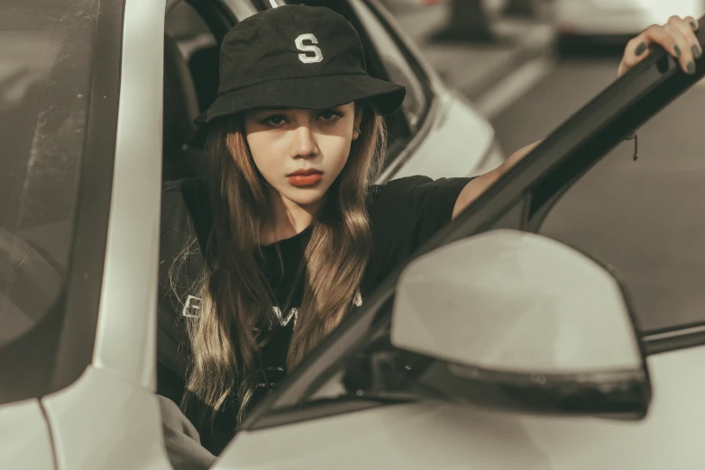 a woman sitting in the driver's seat of a car, inspired by Elsa Bleda, trending on pexels, realism, black cap, blackpink jennie, sigma 85/1.2 portrait, casual clothing style