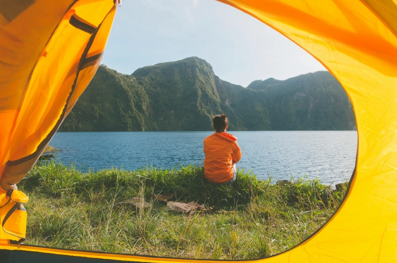 a person sitting inside of a tent next to a body of water, pexels contest winner, chartreuse and orange and cyan, avatar image, rex orange county, tiny person watching