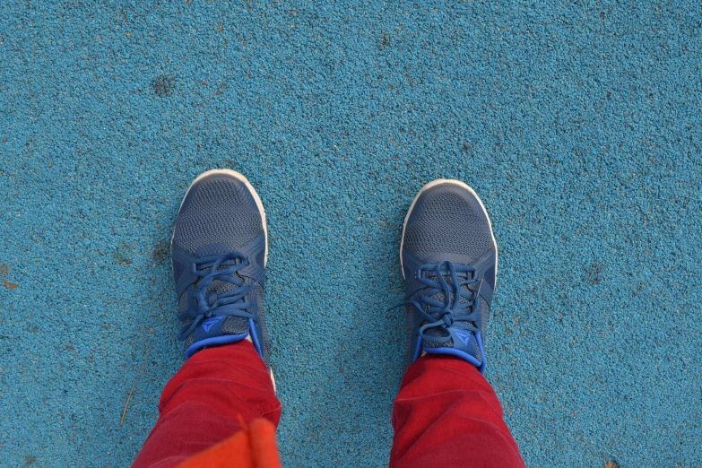 a person standing on a tennis court wearing tennis shoes, blue long pants and red shoes, avatar image, colours, blog-photo