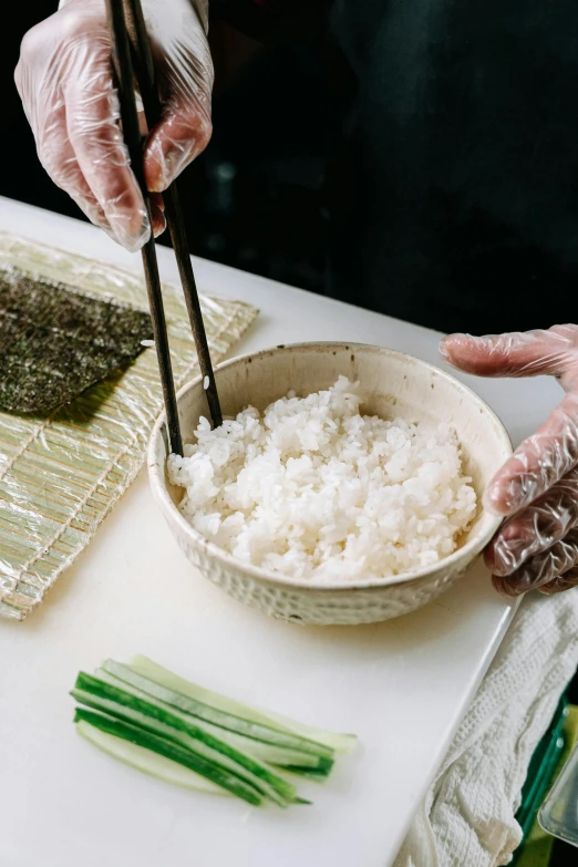 a white table topped with a bowl of rice and chopsticks, process art, hands pressed together in bow, sushi, square, medium