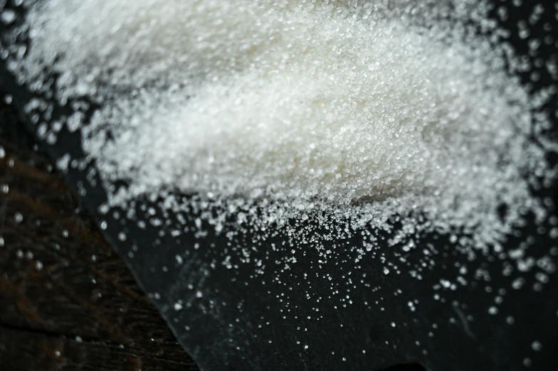 a pile of sugar sitting on top of a wooden table, a portrait, pexels, slush, tryptamine, closeup at the food, close-up imagery