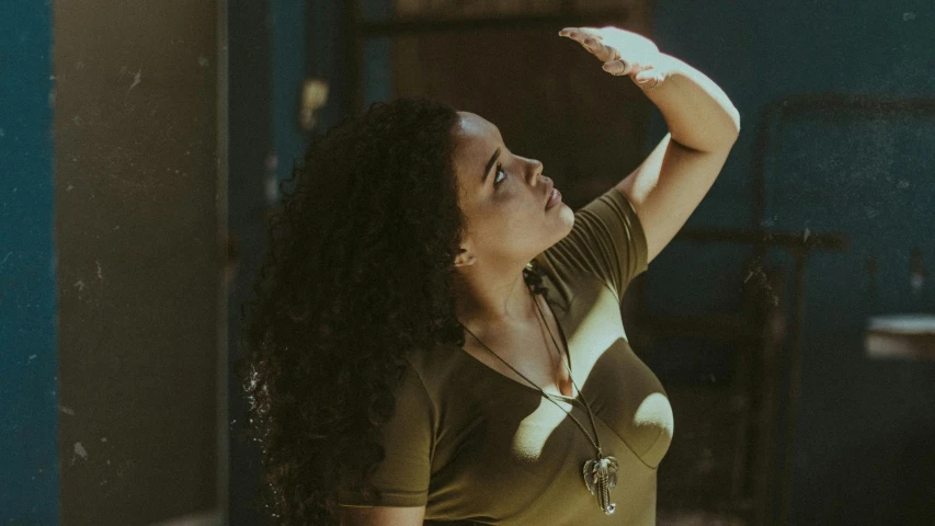 a beautiful young woman holding a tennis racquet, an album cover, pexels contest winner, renaissance, tessa thompson inspired, standing under a beam of light, curls and curves, arms outstretched