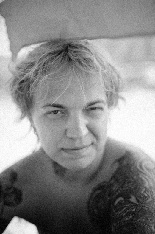 a black and white photo of a woman holding an umbrella, a black and white photo, reddit, photorealism, frank dillane as puck, headshot profile picture, russian criminal tattoos, smug smile