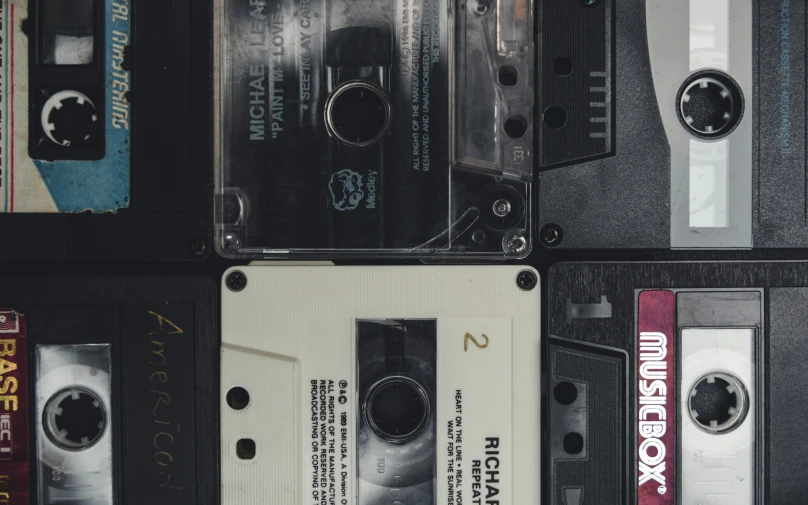 a bunch of cassettes stacked on top of each other, an album cover, unsplash, diptych, michael mann, tape deck, light and dark