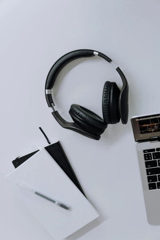 a laptop computer sitting on top of a white desk, an album cover, trending on pexels, gaming headset, wearing black headphones, thumbnail, no - text no - logo