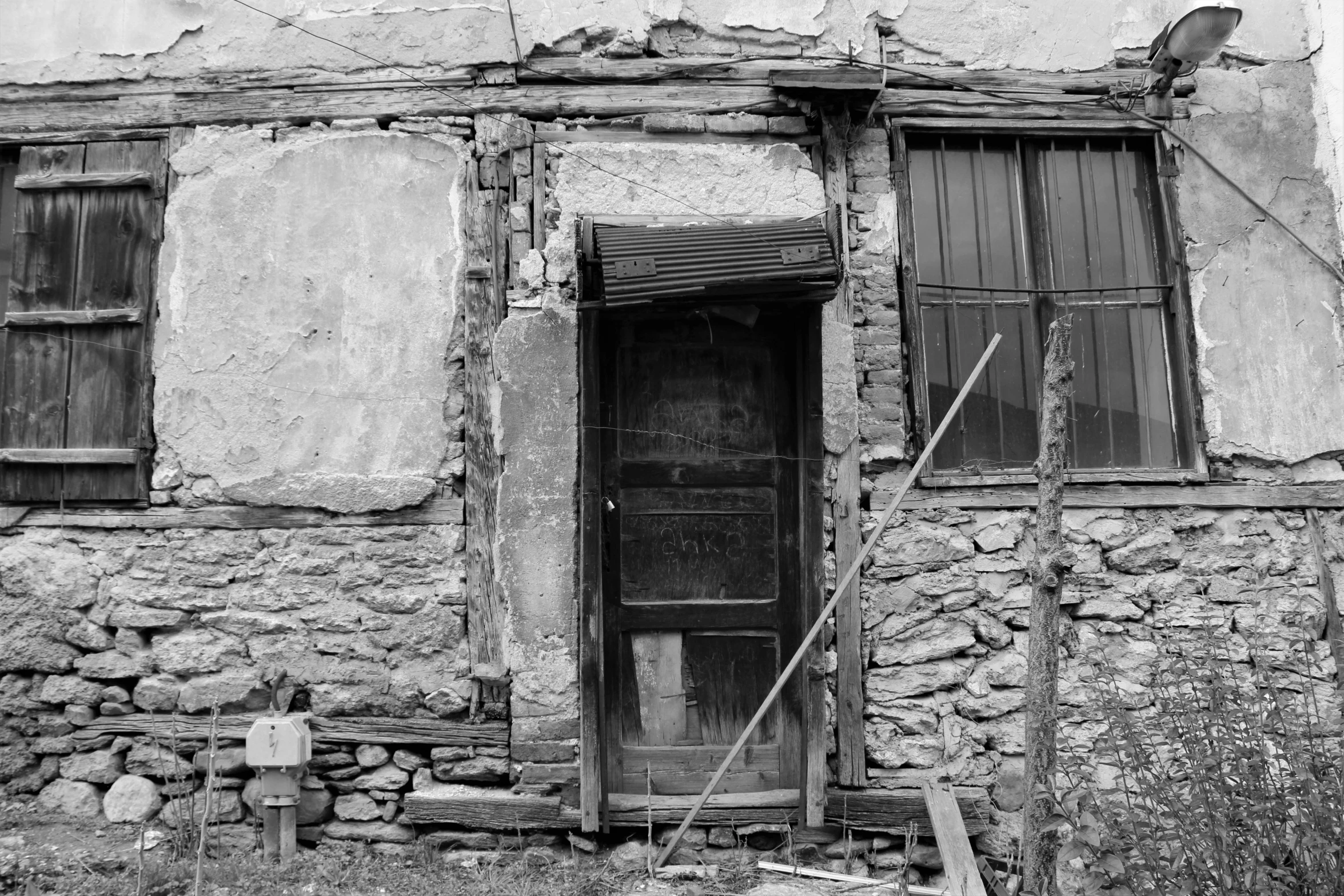 a black and white photo of an old house, a portrait, by Kristian Zahrtmann, flickr, entrance to abandoned mine, 2000s photo, under repairs, taras susak