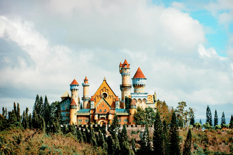 a castle sitting on top of a lush green hillside, inspired by disney, unsplash contest winner, art nouveau, colorful architecture, finland, cardboard, promo image