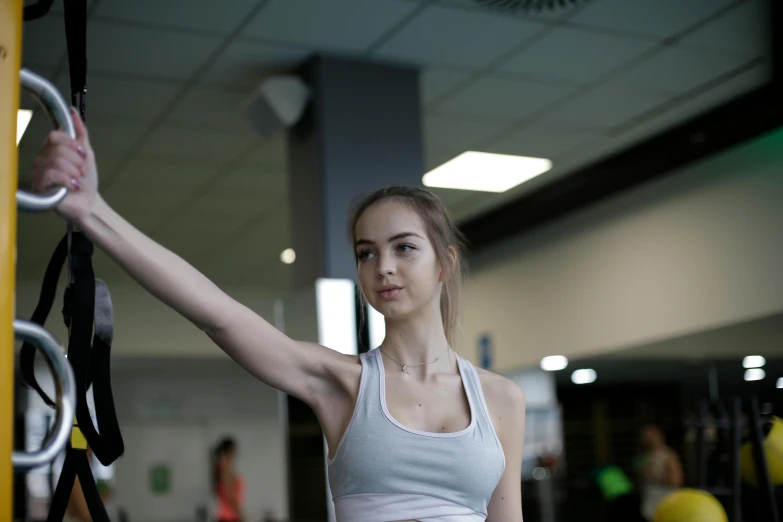 a beautiful young woman working out in a gym, by Emma Andijewska, pexels contest winner, arabesque, looking from shoulder, low quality photo, mid 2 0's female, wingspan