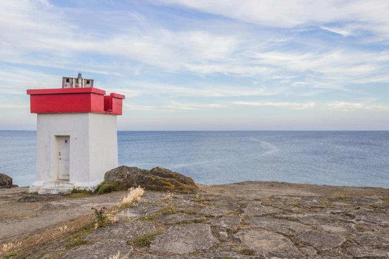 a red and white lighthouse sitting on top of a rock, views to the ocean, kirbi fagan, looking around a corner, subtle detailing