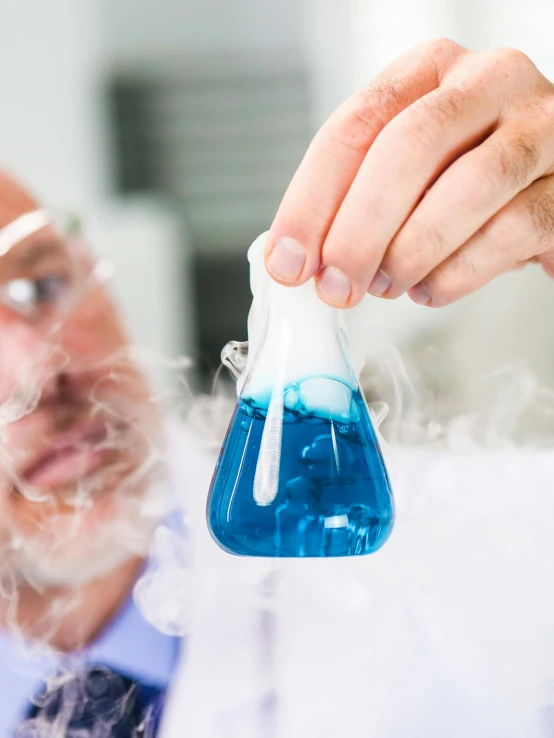 a man in a lab coat holding a blue liquid, trending on unsplash, liquid smoke twisting, avatar image, engineer, silicone skin