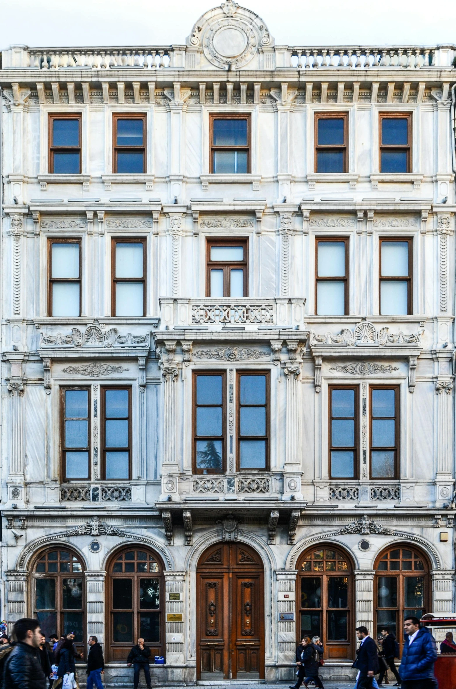 a group of people walking in front of a building, an album cover, inspired by Matthias Jung, pexels contest winner, art nouveau, istanbul, front elevation view, stone facade, window ( city )