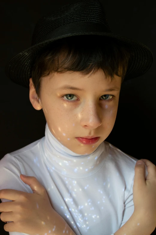 a young boy wearing a black hat and white shirt, inspired by Cindy Sherman, pexels, holography, porcelain highlighted skin, sparkly, ignant, mime