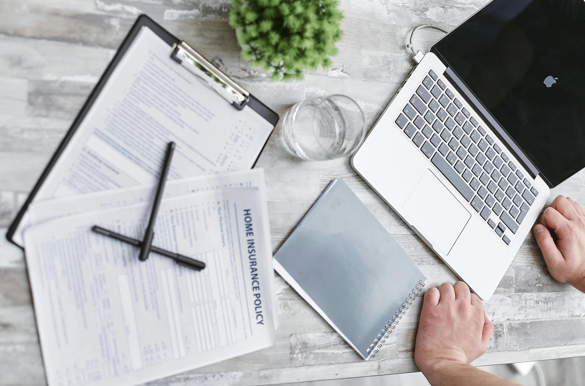 a person sitting at a table working on a laptop, private press, selling insurance, 9 9 designs, holding a clipboard, unblur