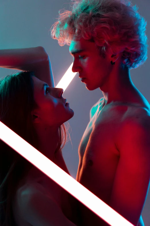 a man and a woman standing next to each other, poster art, pexels contest winner, light and space, glowing neon skin, modeling photography, lesbians, light sabers