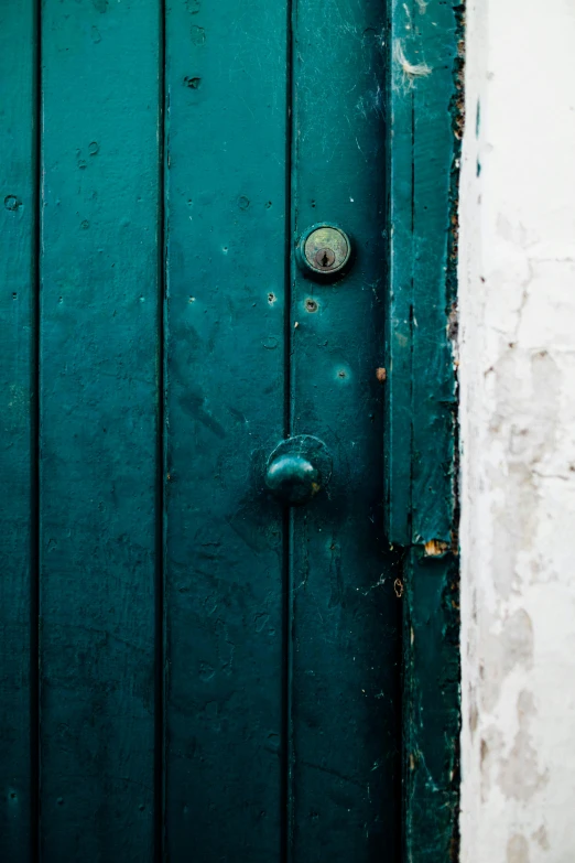 a close up of a door on a building, by Peter Churcher, unsplash, blue and green colours, rough and moody, green and white, copper and deep teal mood